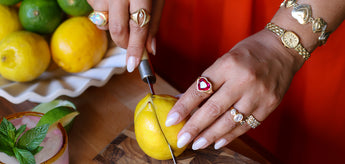 Hands with jewelry slicing a lemon
